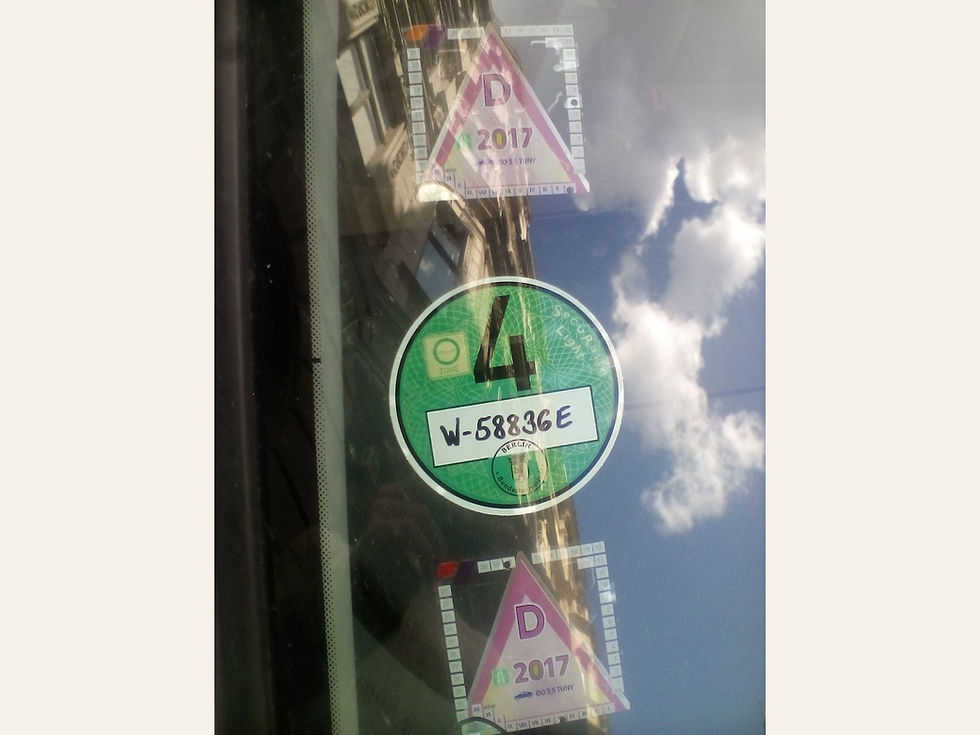 Green German emissions sticker displayed inside a car windscreen