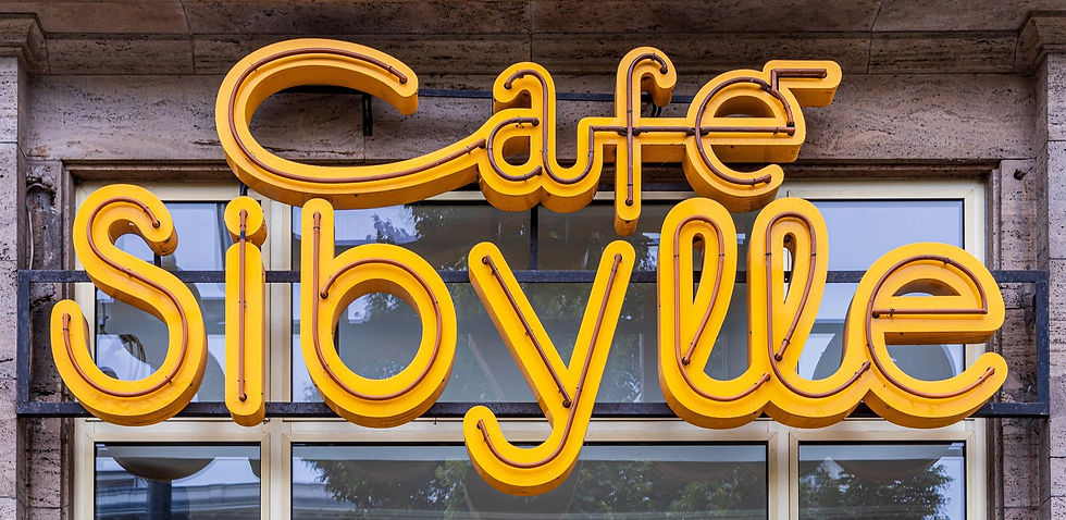 The yellow neon Café Sibylle lettering on the facade at Karl-Marx-Allee 72