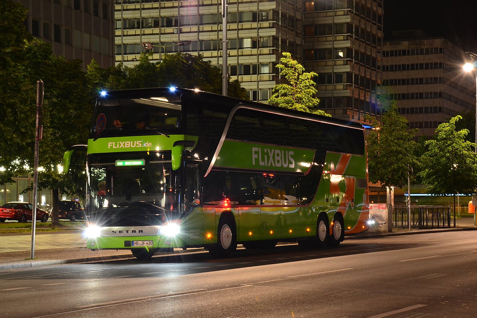 A green FlixBus double-decker at the Alexanderplatz coach stop at night