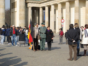 Crowds and a costumed photo tout in front of the Brandenburg Gate on Pariser Platz
