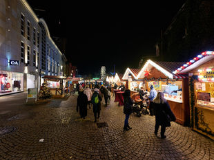 A Berlin Christmas market glowing with lights and wooden stalls on a December evening