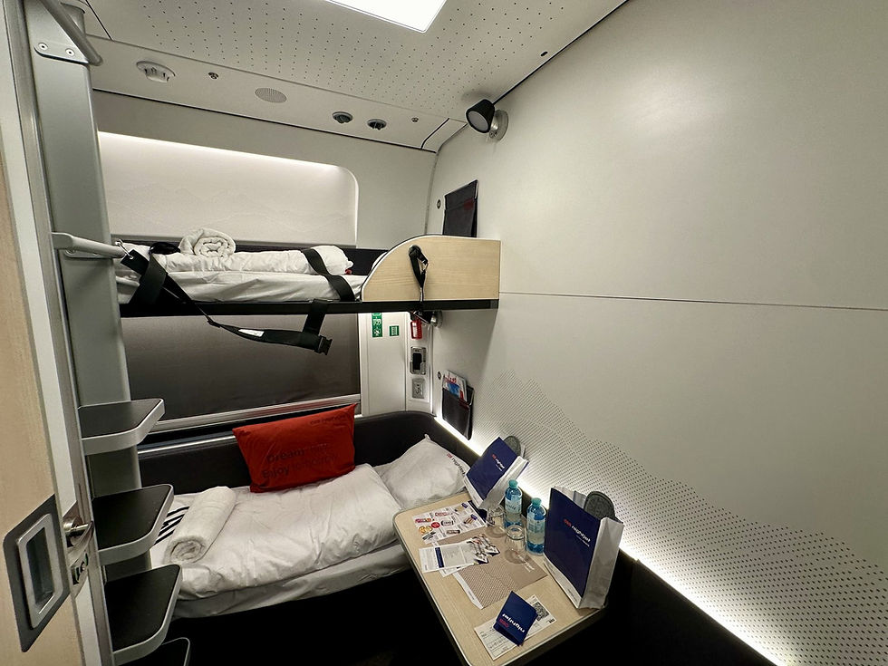 Interior of a modern Nightjet sleeping cabin with a made bed and folded towels