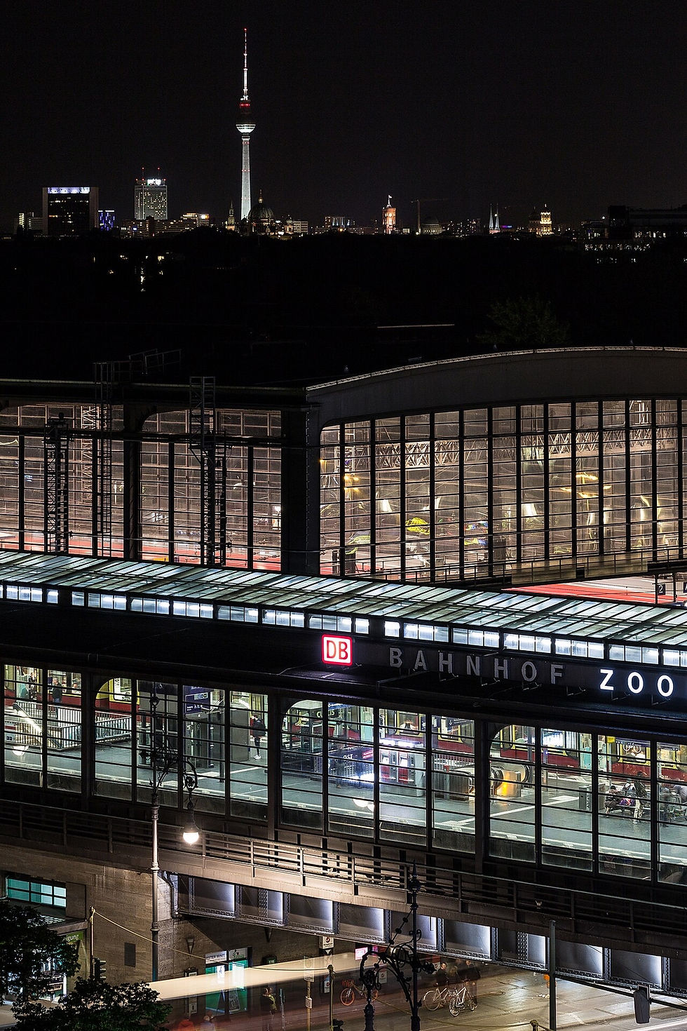 Bahnhof Zoologischer Garten at night with the illuminated Bahnhof Zoo sign and the TV Tower on the horizon
