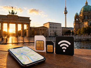 Smartphone with map, three SIM cards, and Wi-Fi symbol on wooden surface. Background shows sunset over Berlin landmarks, creating a warm mood.