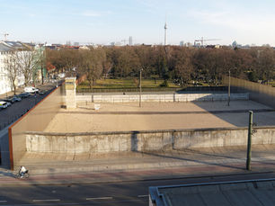 Preserved stretch of the Berlin Wall border strip in central Berlin, with the TV Tower and Berliner Dom on the skyline behind it.