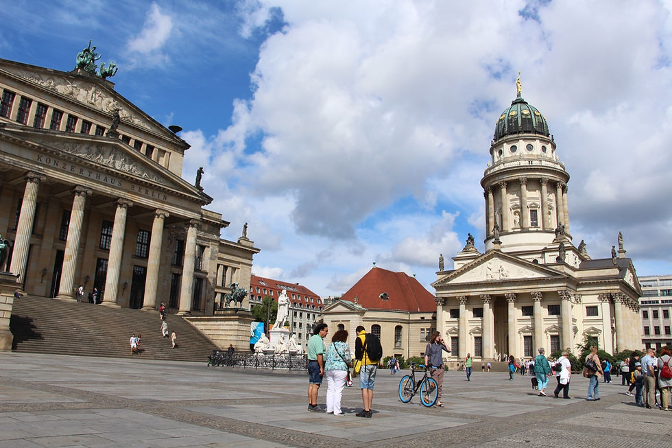 Wide view across Gendarmenmarkt in Berlin, with the Konzerthaus on the left, the Schiller monument in the middle, and the French Cathedral with its green domed tower on the right
