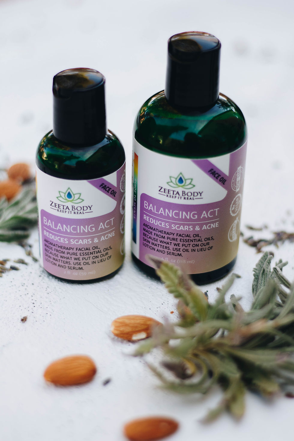 2 sizes of Balancing Act oil with herbs on table