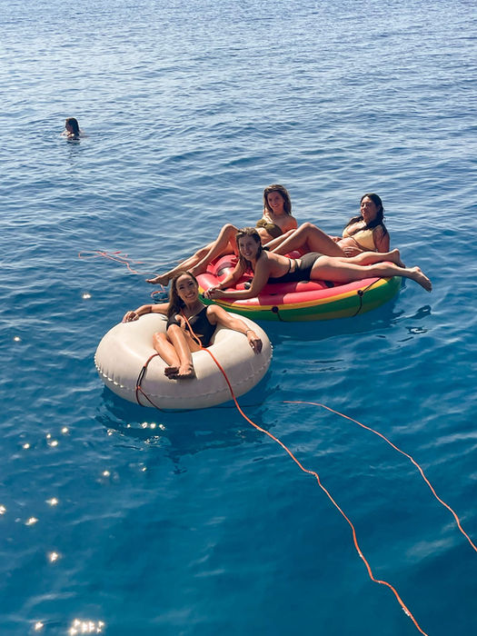 Friends floating on an inflatable raft during an FTLO Crete trip