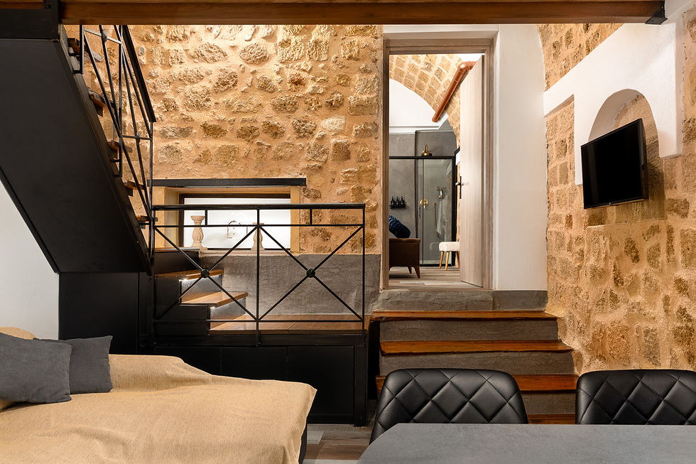 Stone vaulted living area with sofa and wooden furniture — GK Luxury Suites, Rhodes Old Town