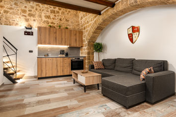 Open-plan living room and kitchen with stone arch — Casa Inverno, GK Luxury Suites, Rhodes Old Town