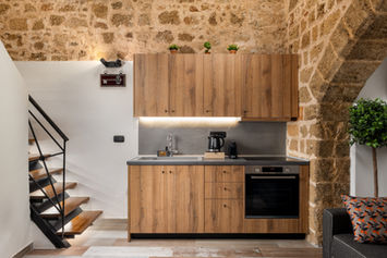 Full equipped kitchen with wooden cabinets and stone arch — Casa Estiva, GK Luxury Suites, Medieval Town of Rhodes