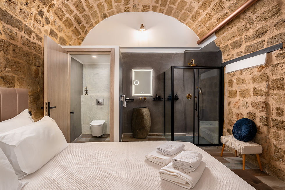 Double bed with white linen and stone wall — GK Luxury Suites, Medieval Town of Rhodes