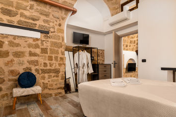 Bedroom with stone vaulted ceiling and en-suite bathroom — GK Luxury Suites, Medieval Town of Rhodes