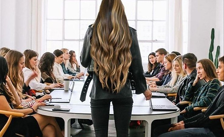 women around table with one woman standing in leadership