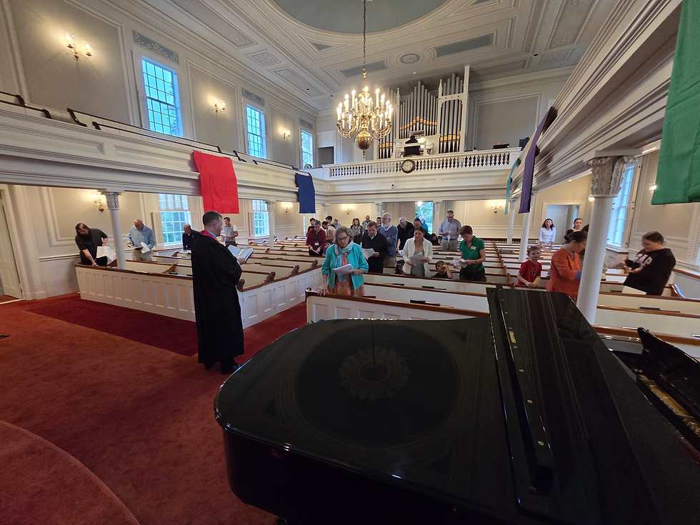 Pastor preaching to congregation in sanctuary filled with people