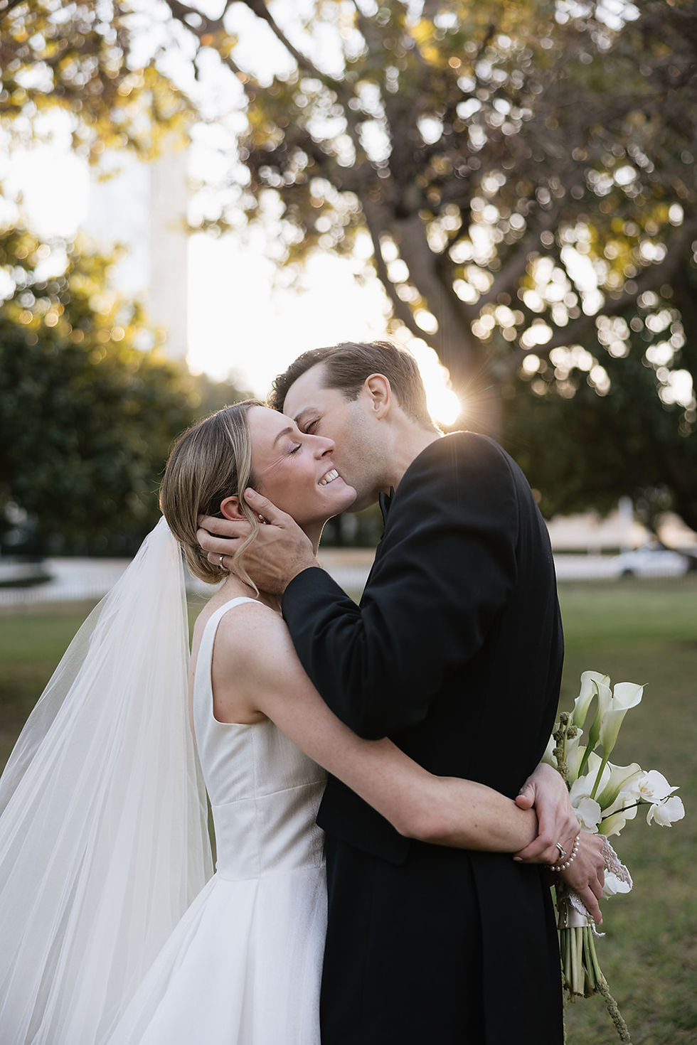 A newlywed couple kissing at golden hour, so glad they avoided wedding planning mistakes.