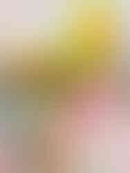 Colorful tablescape close-up featuring yellow zinnias, pink anthurium, and green glass goblets for a vibrant summer wedding vibe