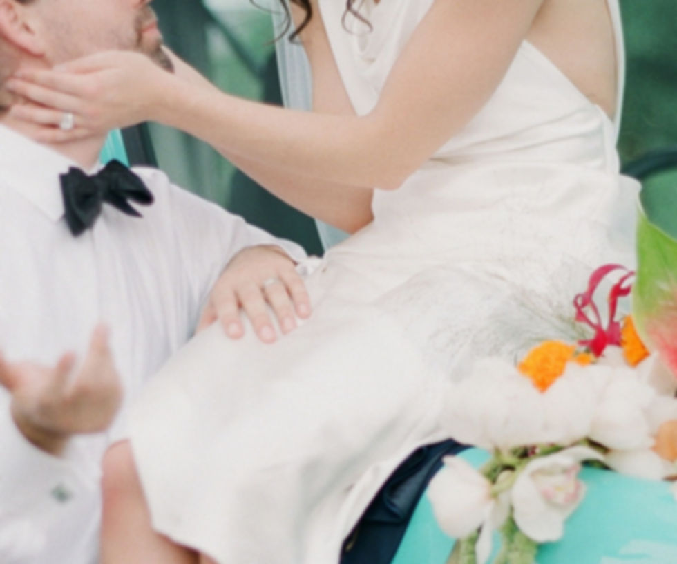 Joyful wedding couple celebrating in vintage Bronco with colorful floral bouquet | Austin wedding planning