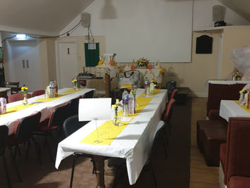 Function room decorated with yellow table runners for party