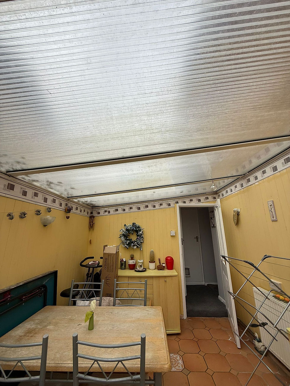 Worker using a cordless drill to attach panels to a conservatory roof.