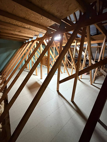 Partially boarded attic space under construction with insulation boards visible on floor