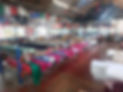 Long perspective view of an indoor warehouse filled with rows of fabric bolts