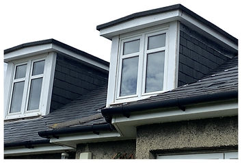 Several angled rooftops with worn and weathered wooden shingles
