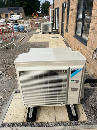 Single heat pump outdoor unit positioned on a concrete base by a lawn