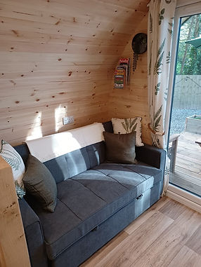 Interior view of horizontal timber cladding featuring a circular window overlooking a green field