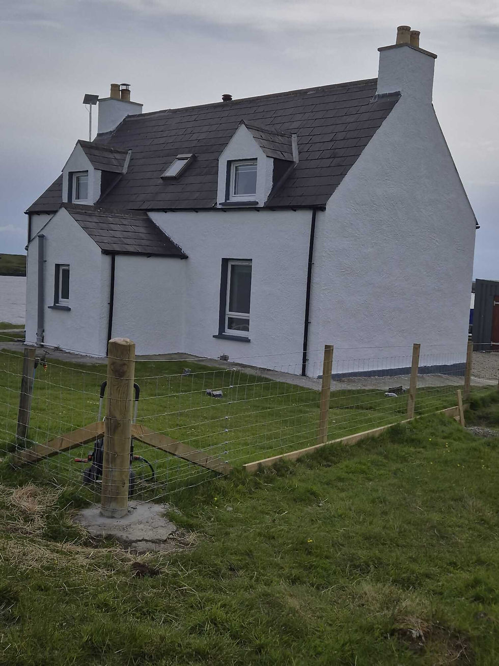 Modern two-storey house with site safety and considerate constructors signs in front.