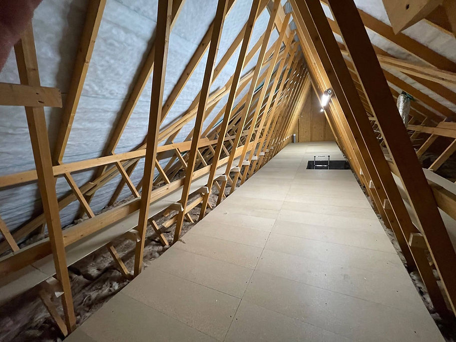 Looking straight down a broad wooden storage pathway built inside an attic