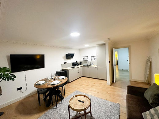 An open plan apartment room featuring a round dining table