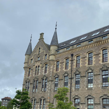 Exterior view of a grand historic stone building with turret details
