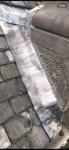 Lead valley flashing installed tightly against slate roof tiles