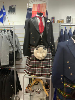 Formal black Prince Charlie jacket and waistcoat outfit paired with a traditional tartan kilt on a store mannequin