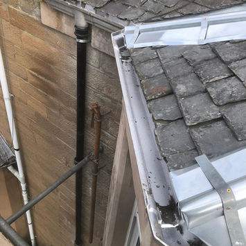 Close-up of a metal rainwater downpipe attached to a building exterior