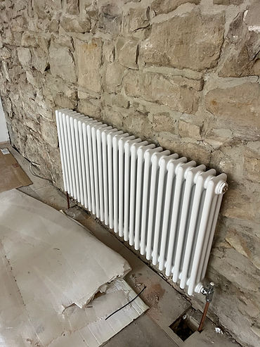 Large traditional white multi-column radiator installed beneath a window