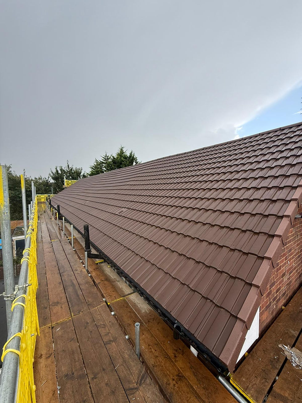 A brick house with scaffolding is undergoing roof repairs, showing new tiles partially installed.