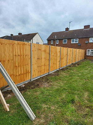New wooden lap panel garden fence installed along a neat lawn border