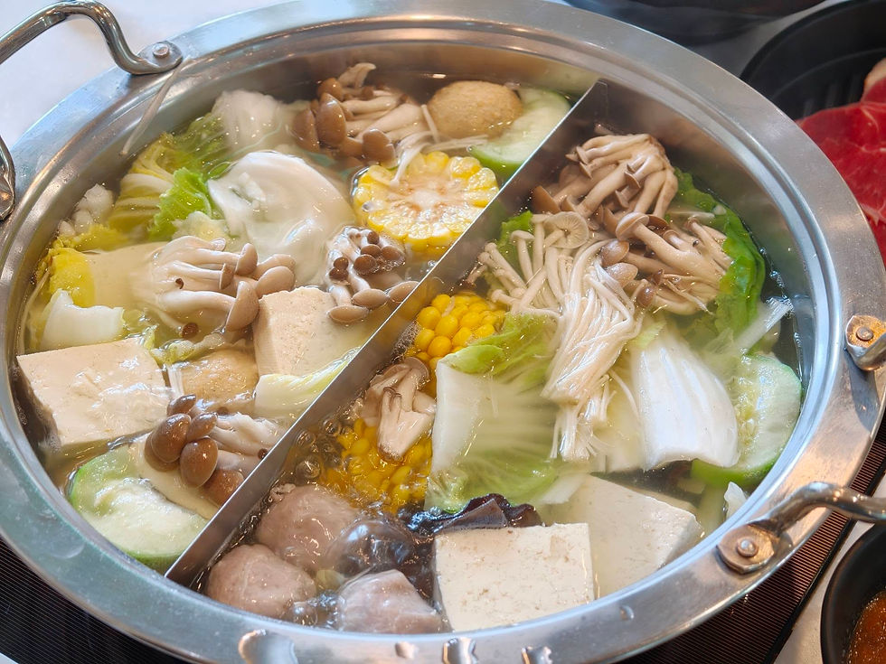 冒著熱氣的雙味火鍋,鍋內擺滿了玉米、豆腐、多種菇類與新鮮青菜,色香味俱全。
