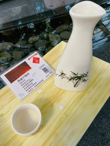 善化糖廠曲水流觴茶席特寫,木質托盤上擺放著精緻瓷瓶與介紹詩卡。
