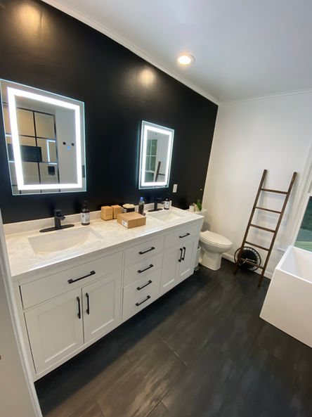 Black accent wall with dark wood accents and white vanity