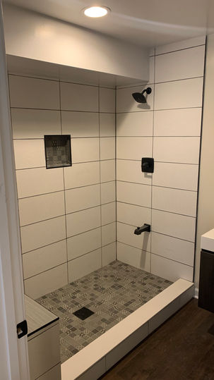 Shower with large white subway tile and niche