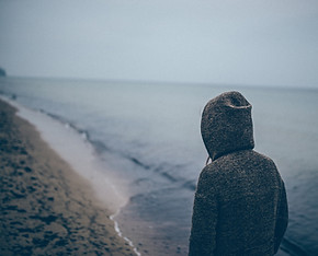 Man in sweatshirt on beach
