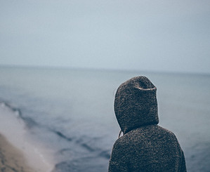 Man in sweatshirt on beach