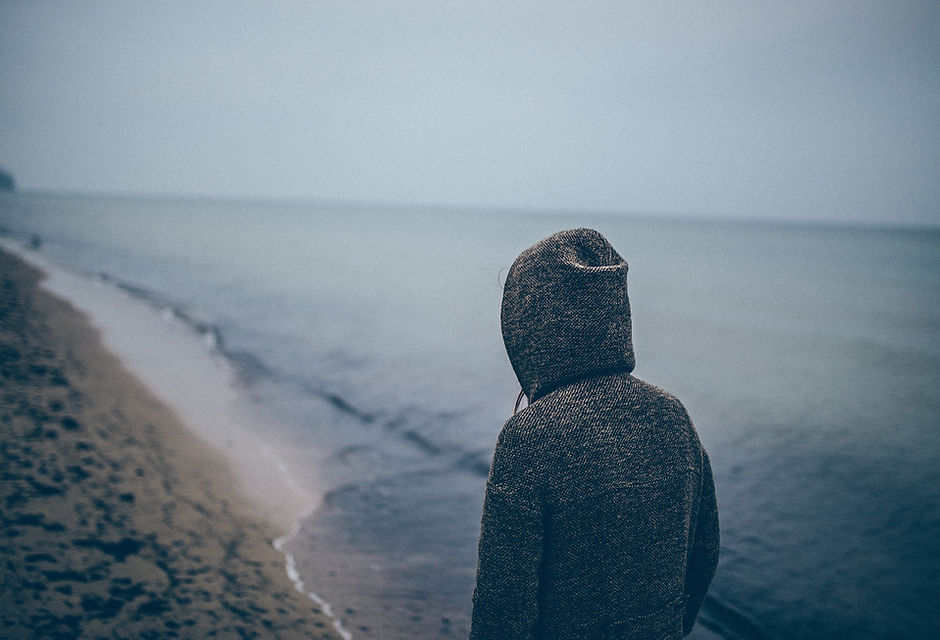 Man in sweatshirt on beach