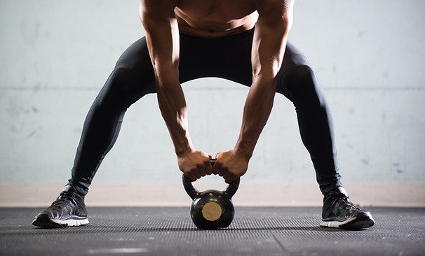 Muscular Man Lifting Kettle Ball