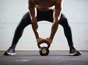 Muscular Man Lifting Kettle Ball