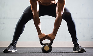 Muscular Man Lifting Kettle Ball