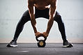 Muscular Man Lifting Kettle Ball